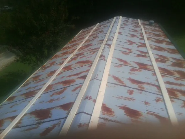 Rusted metal roof panels with new wood purlins before replacement — Storm Damage Roof Repair in Honeoye Falls by Roofing Brothers